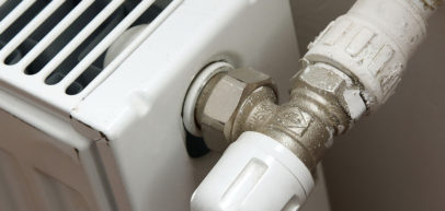A T shaped water piping connection on the side of a water gas heater.